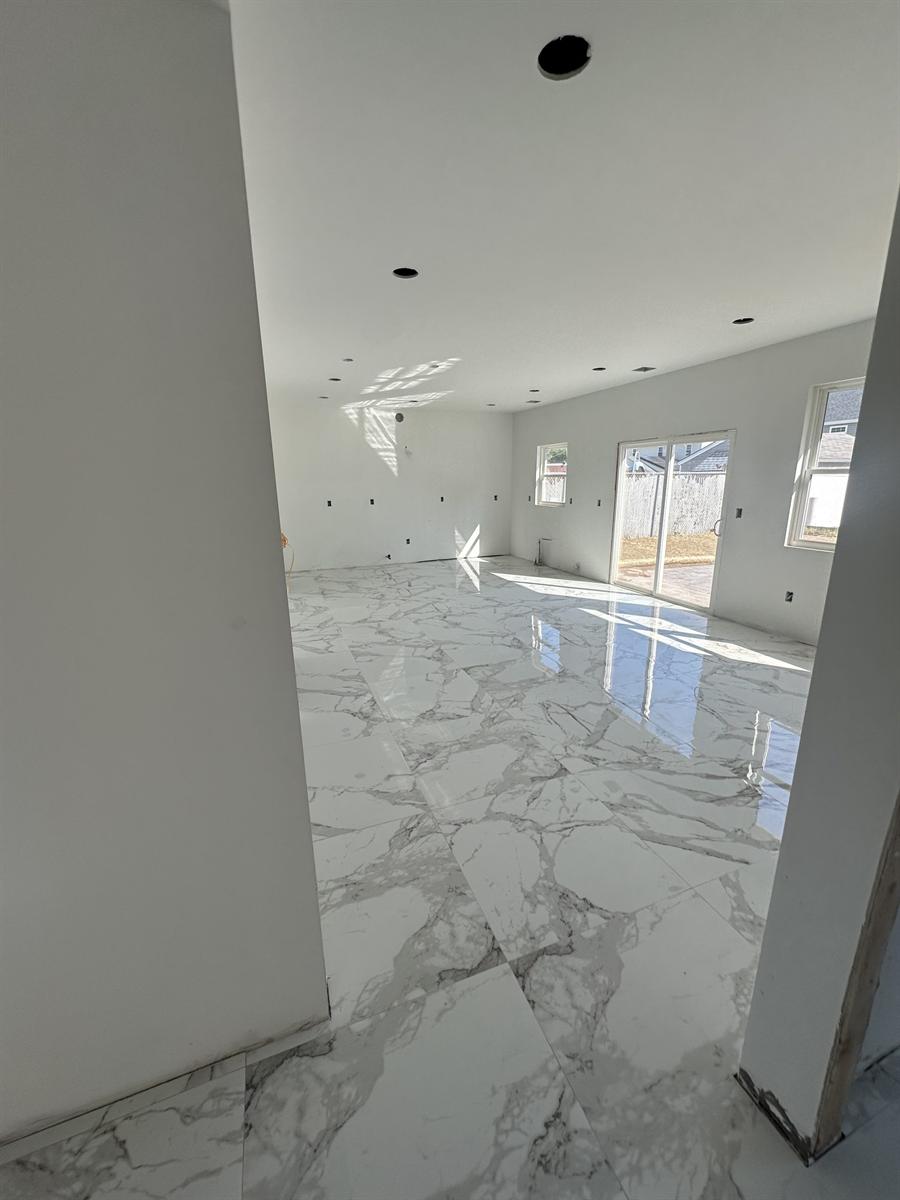 Polished large-format porcelain floor installed by Silcam Tile in an open-plan New Jersey home